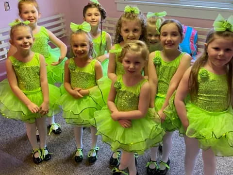 a group of girls in green dresses