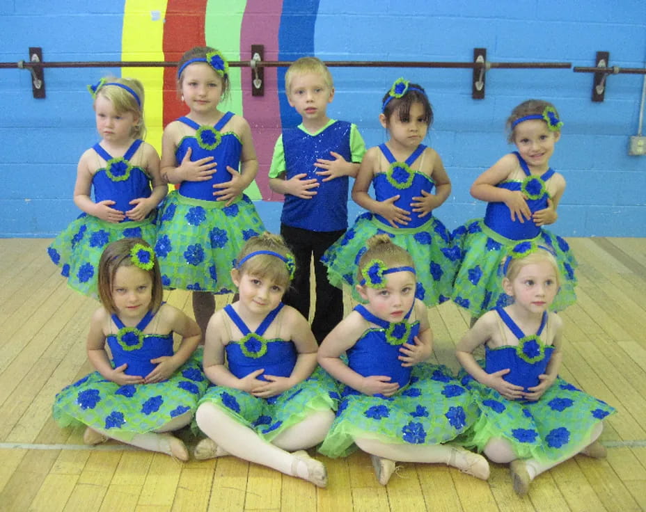a group of children in blue dresses