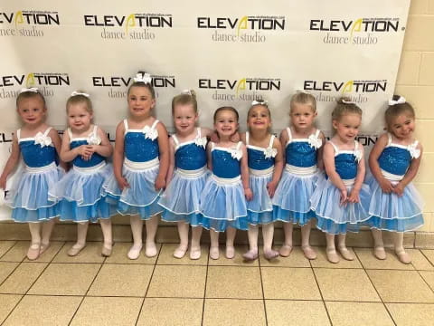 a group of girls in blue dresses