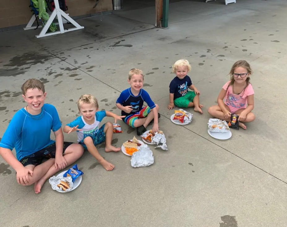 a group of kids sitting on the sand
