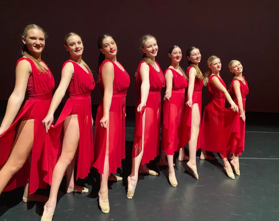 a group of women in red dresses