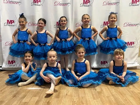 a group of girls in blue dresses