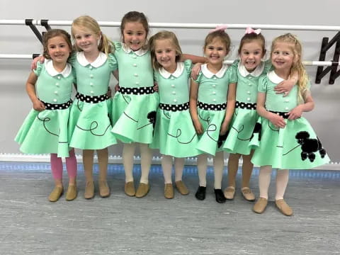 a group of girls in green dresses