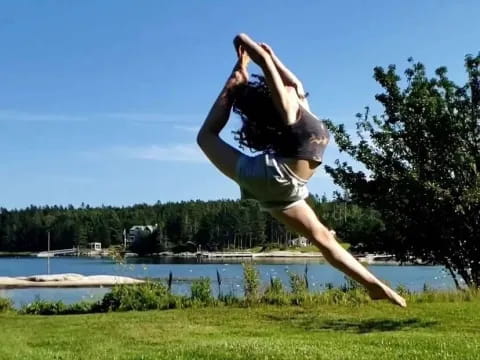 a person doing a handstand in the air above grass