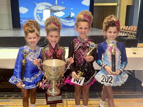 a group of girls holding trophies