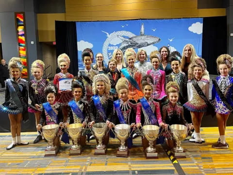 a group of people posing for a photo with trophies