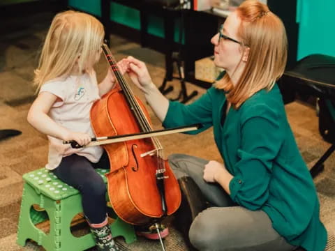 a person playing a cello next to a young girl