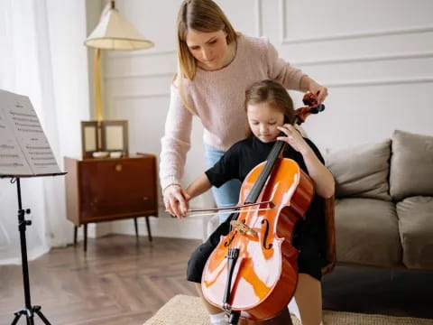 a person playing a guitar next to a boy playing a guitar