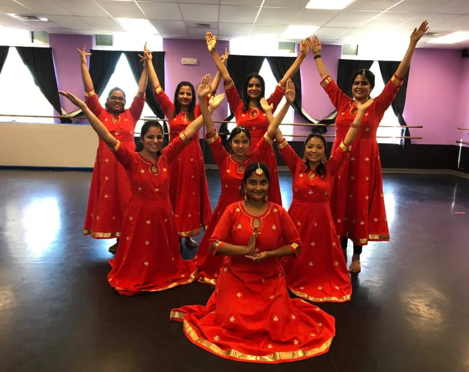 a group of women in red dresses