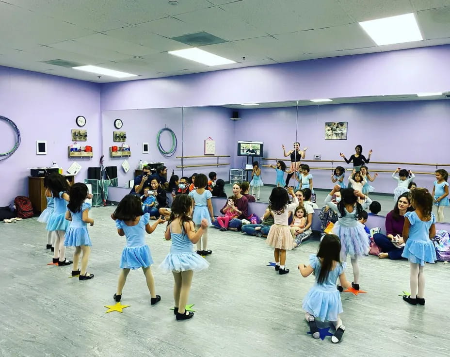 a group of children dancing in a room with purple walls