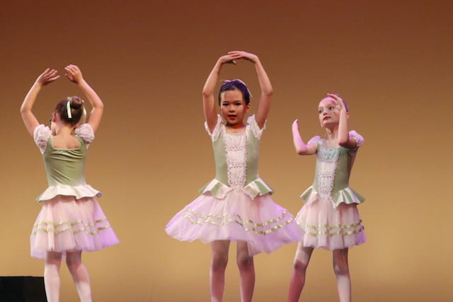a group of girls wearing dresses and dancing
