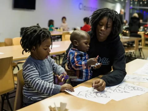 a person and two children sitting at a table