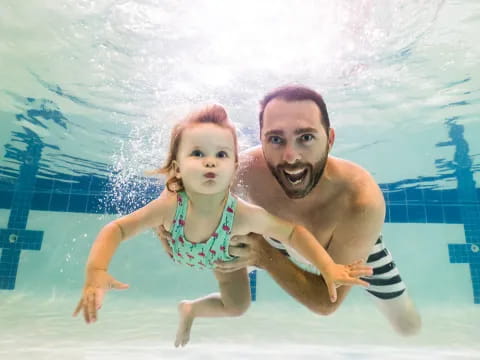 a person and a girl in a pool