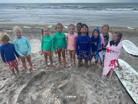a group of children posing for a photo on a beach