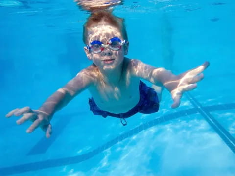 a person in a pool wearing goggles and swimming