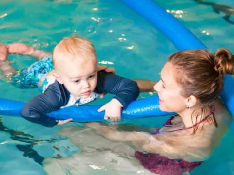 a person and a baby in a pool