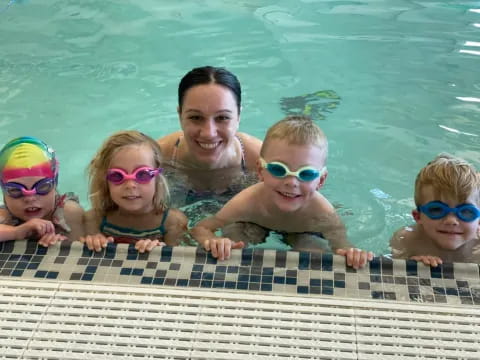 a person and a group of children in a pool