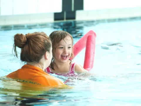 a person and a girl in a pool