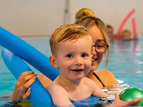 a person and a baby in a pool