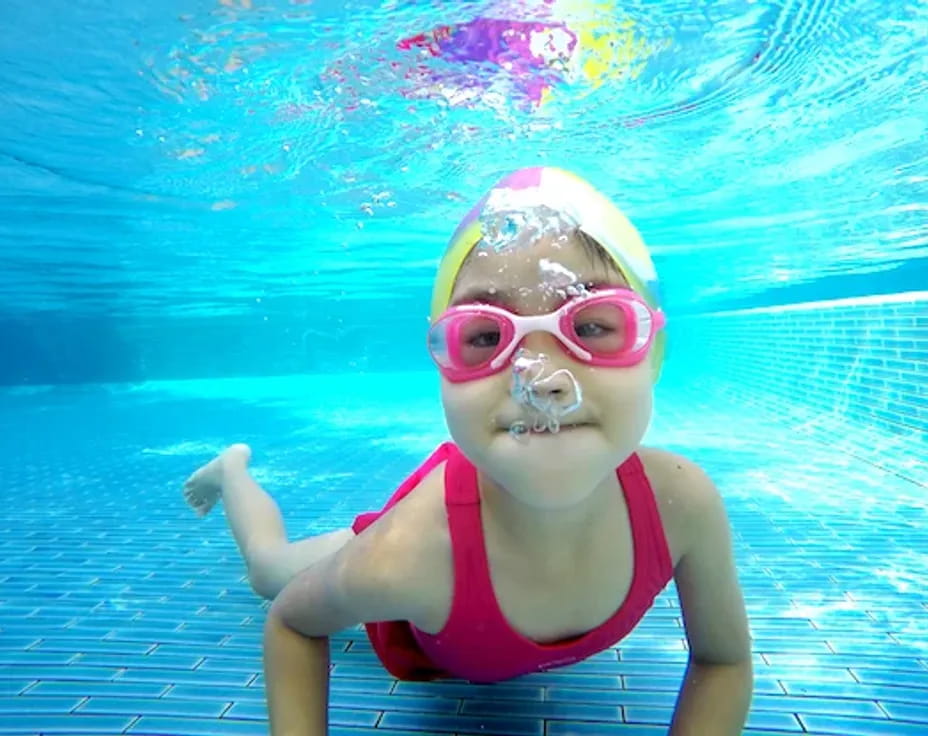 a girl wearing goggles and swimming