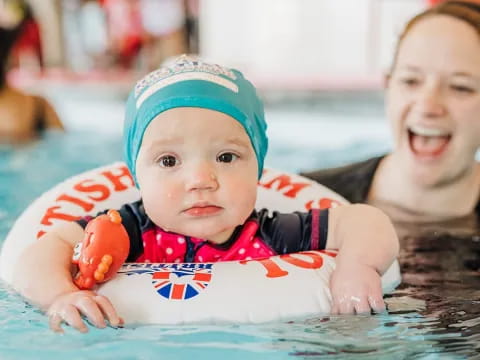 a person and a baby in a pool