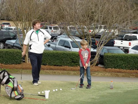 a person and a boy playing golf
