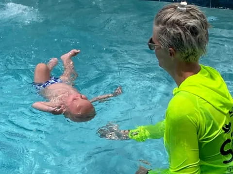 a person and a baby in a pool
