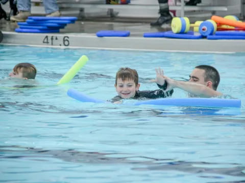 a person and a boy in a pool