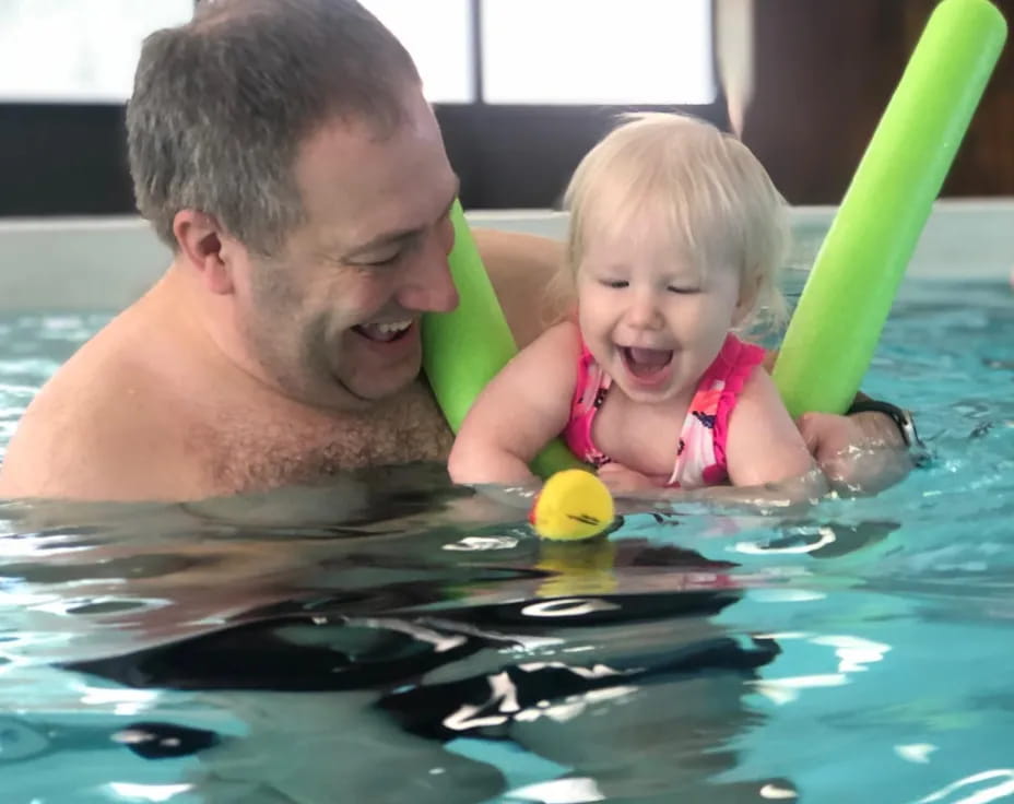 a person and a baby in a pool