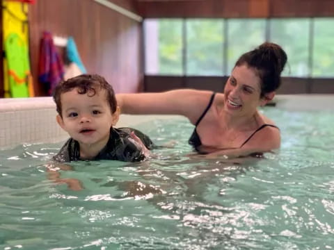a person and a boy in a pool