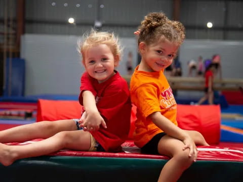 two children sitting on a mat