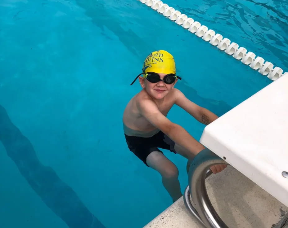 a person in a yellow hat in a pool