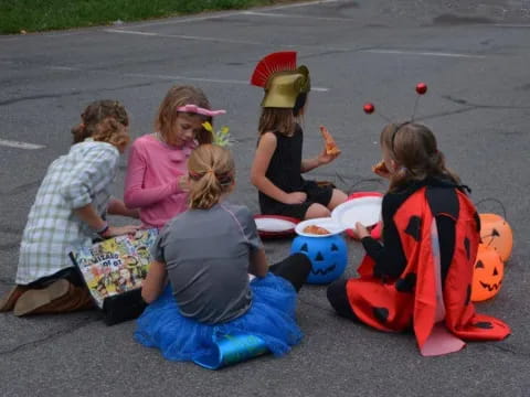 a group of people sitting on the ground eating