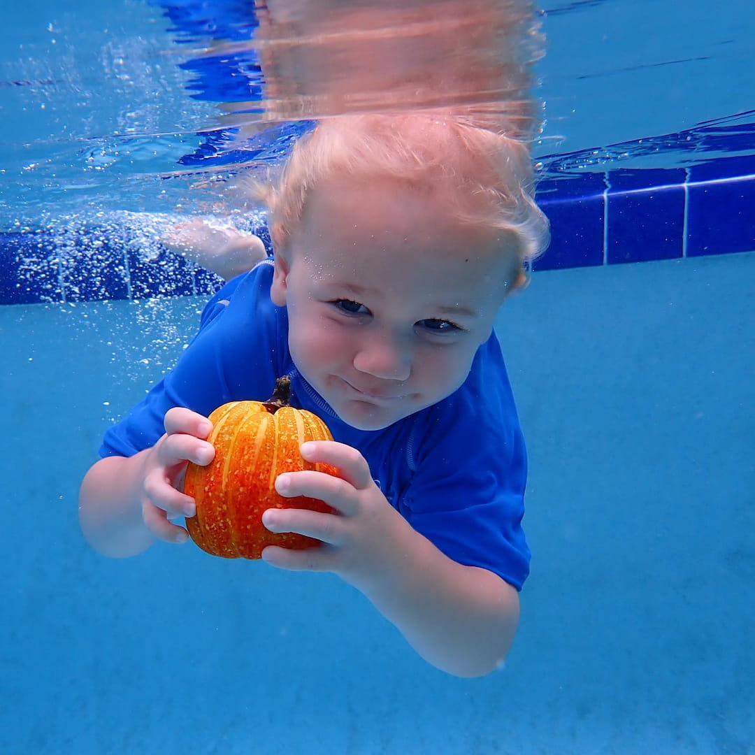 a child in a pool holding a ball
