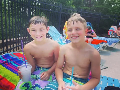 two boys sitting on a blanket