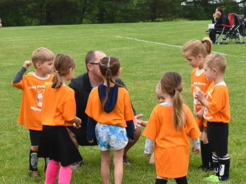 a group of children in orange shirts