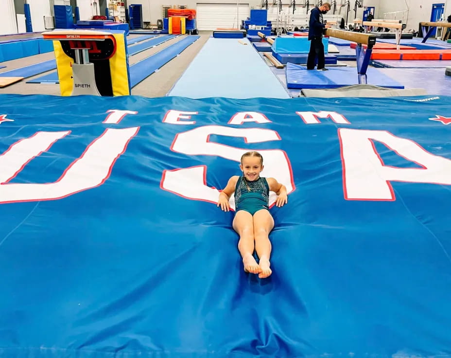 a boy sitting on a blue mat