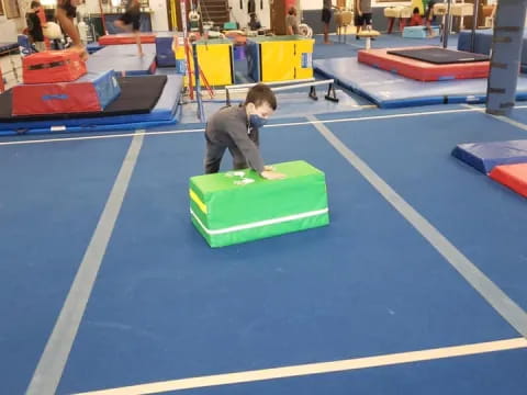 a boy sitting on a mat