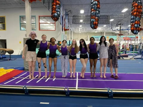 a group of women posing for a photo on a purple mat
