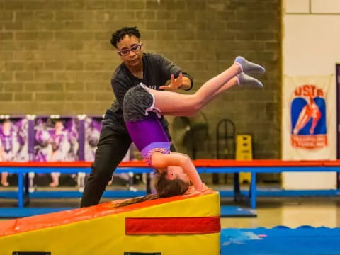 a man holding a woman in a gym