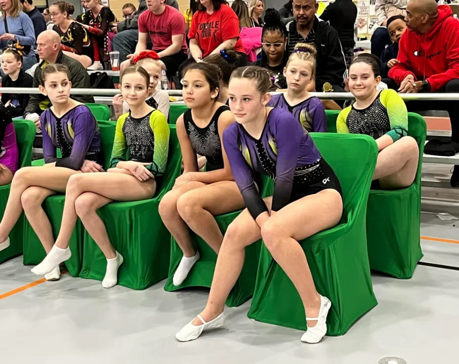 a group of people sitting in green chairs