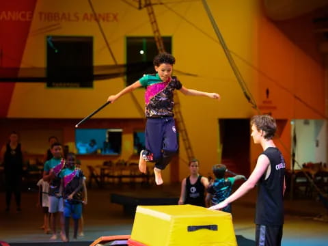 a boy jumping on a trampoline