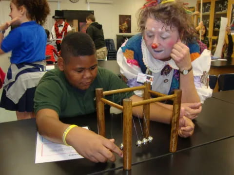 a person and a boy working on a model of a ship