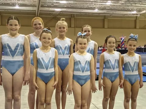 a group of girls in swimsuits standing in a pool