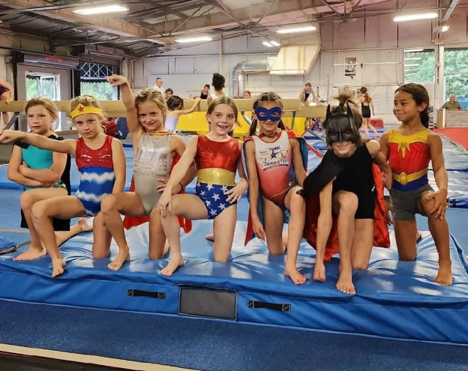 a group of kids in swimsuits on a blue mat