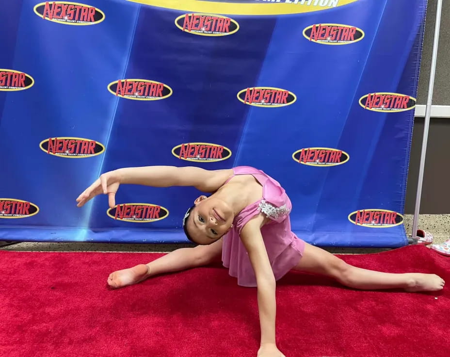 a person lying on the back on a red carpet in front of a blue wall with logos
