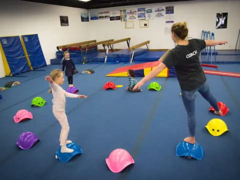 a person and a child playing on mats in a gym