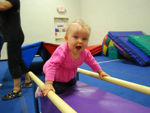 a baby sitting on a blue mat