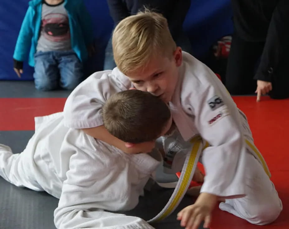 a man helping a boy do push-ups