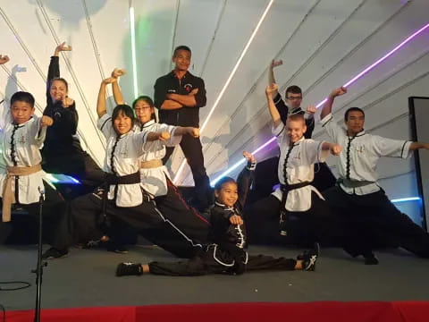 a group of people in white karate uniforms jumping in the air